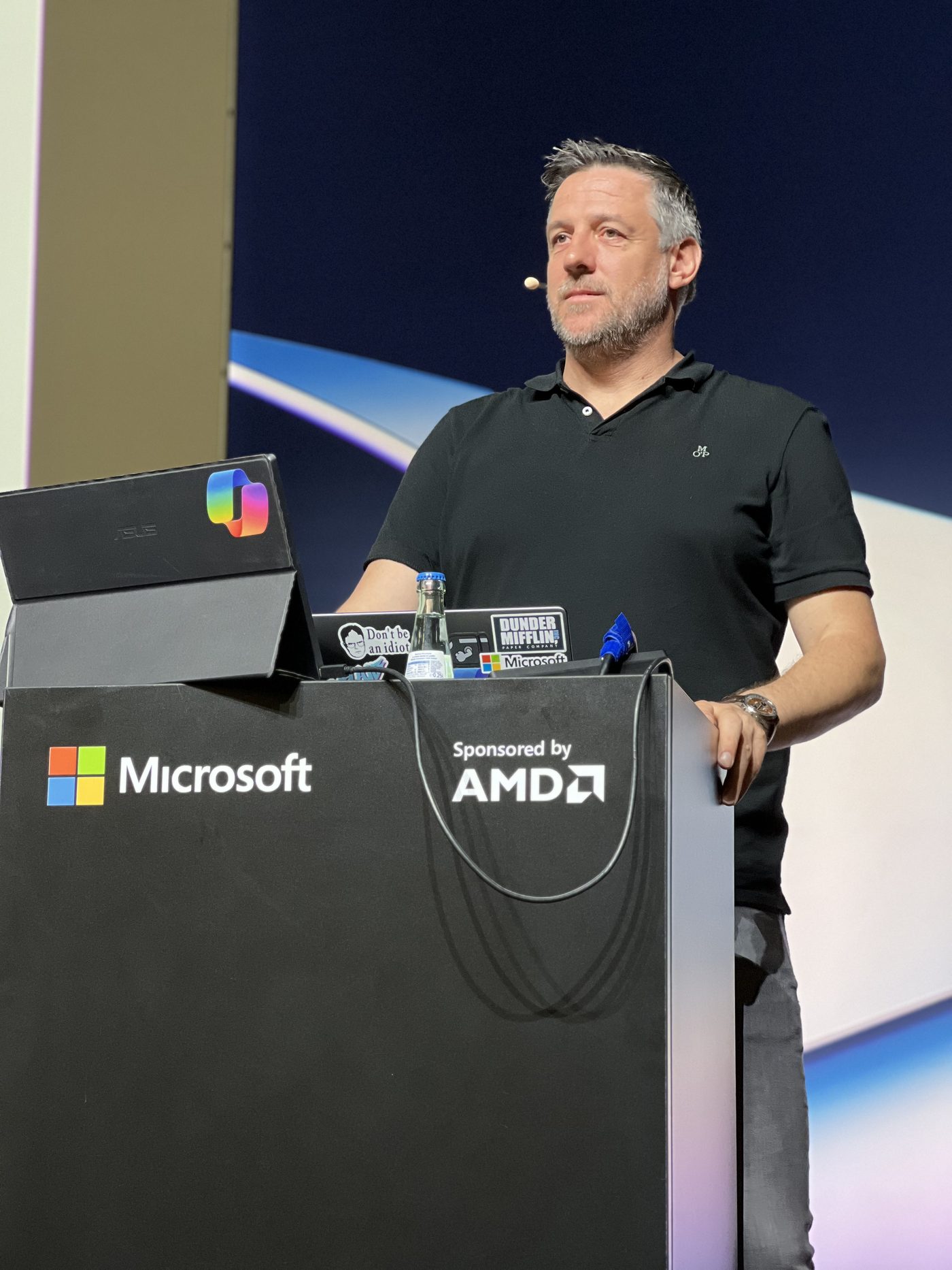 Alex de Jong speaking on stage at a Microsoft event